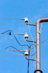 Low angle view of power lines against blue sky