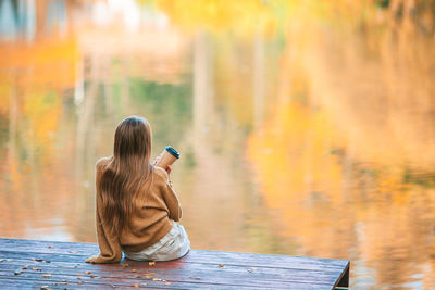 Rear view of woman photographing outdoors