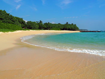 Scenic view of beach against blue sky