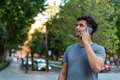 Young latin man in the city talking by mobile phone.