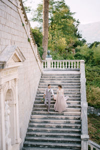 Rear view of couple walking on staircase