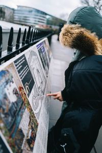 Side view of woman standing in city during winter