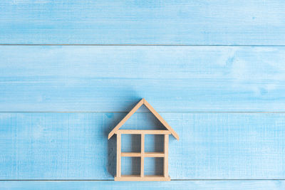 Directly above shot of wooden model home on blue table