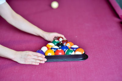 Close-up of hand playing with ball on table