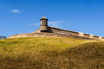 Low angle view of lighthouse on field against sky