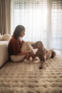 Side view of woman sleeping on bed at home