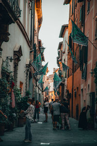 People walking on street amidst buildings in city