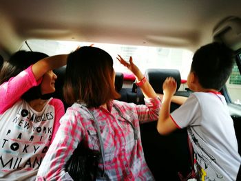 Rear view of women standing in bus