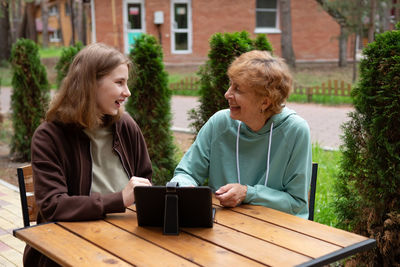 Portrait of smiling friends sitting on field