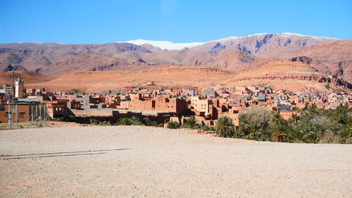 Houses and mountains against blue sky