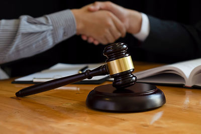 Close-up of hand holding cup on table