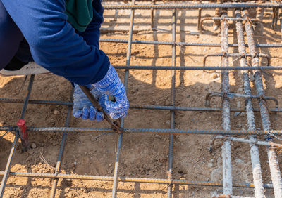 Worker using wire and pliers to tie the rebar for building foundations