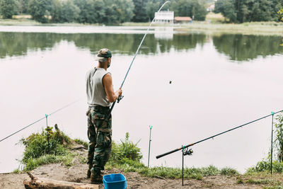 A young fisherman catches fish on a lake or river, prepares tackle and bait. hobbies, weekend