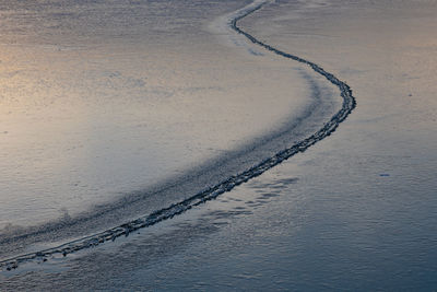 High angle view of tire tracks on beach