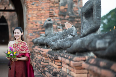 Midsection of woman at temple against building