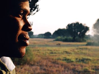 Close-up of man looking away against sky 