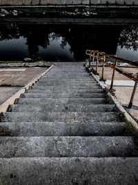 Footpath by railing by lake