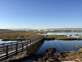 Scenic view of river against clear blue sky