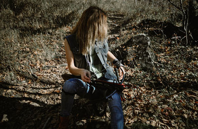 Midsection of woman sitting in forest