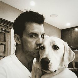 Portrait of young man with dog at home