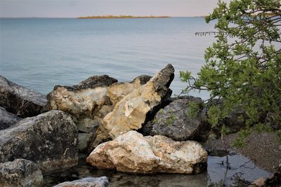 Rocks by sea against sky