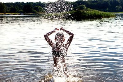 Man splashing water in lake