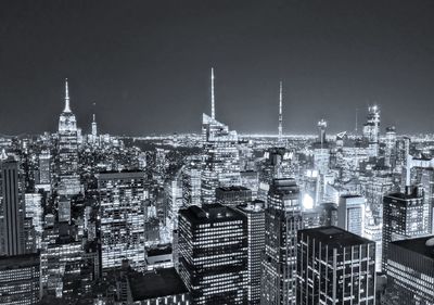 Illuminated buildings in city against sky at night