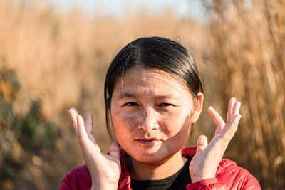 Close-up portrait of young woman against plants