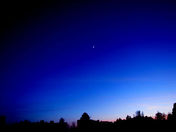 Silhouette of trees against sky at dusk