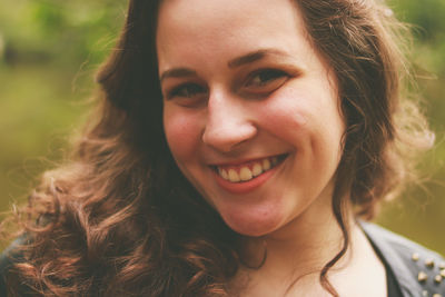 Close-up portrait of smiling teenage girl at park