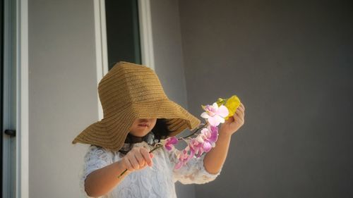 Girl wearing hat holding flowers