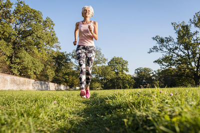 Senior woman running on rural meadow