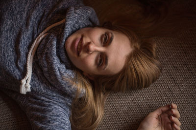 Directly above portrait of woman lying on carpet