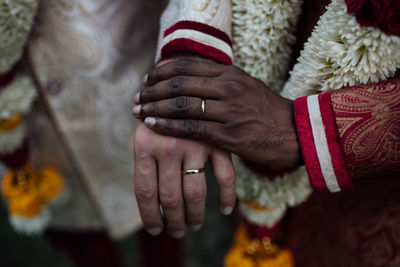 Cropped image of gay men holding hands during wedding ceremony