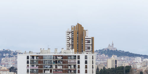 Buildings in city against clear sky