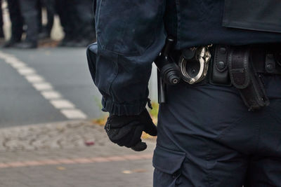 Midsection of police officer standing on road