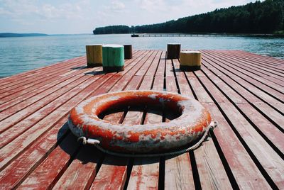 Close-up of chocolate on wooden pier over lake against sky