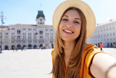 Cultural tourism in italy. self portrait of smiling traveler girl visiting trieste, italy.