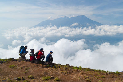 People on mountain against sky