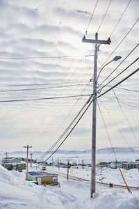 Power lines against sky during winter