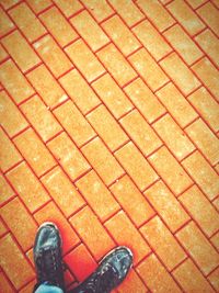 Low section of man standing on tiled floor