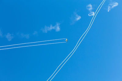 Low angle view of vapor trail against blue sky