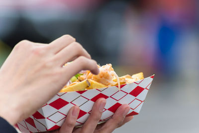 Cropped image of woman holding takeaway food outdoors
