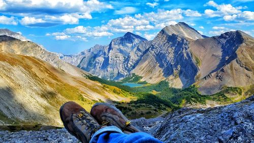 Low section of man on mountain against sky