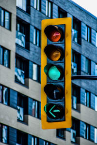 Low angle view of road signal against illuminated building