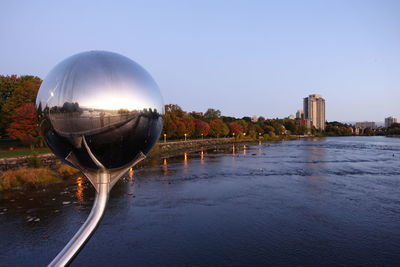 Scenic view of river by buildings against clear sky