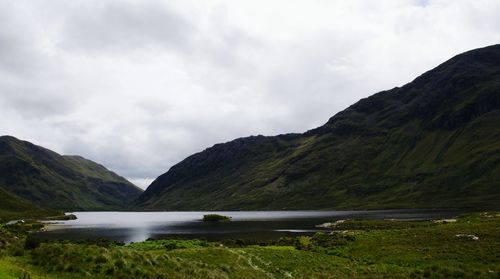 Scenic view of river against cloudy sky