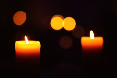 Close-up of illuminated tea light candles in darkroom