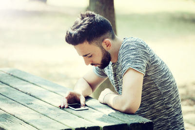 Young man using smart phone on table