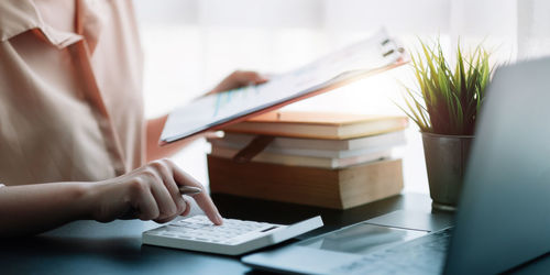 Midsection of man using laptop on table